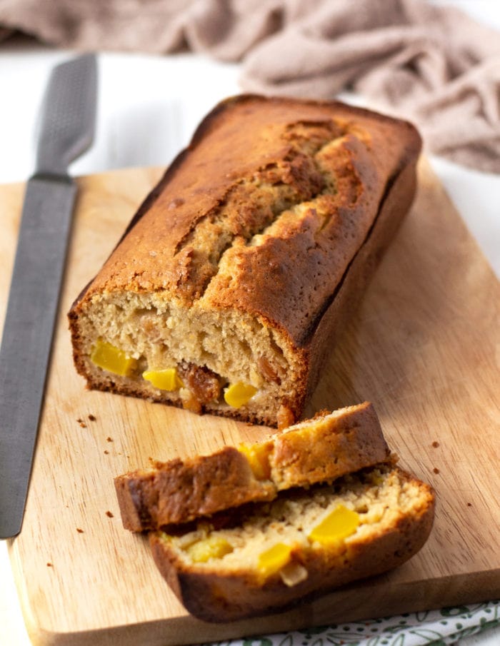 photo of a loaf of mango bread with two slices cut off