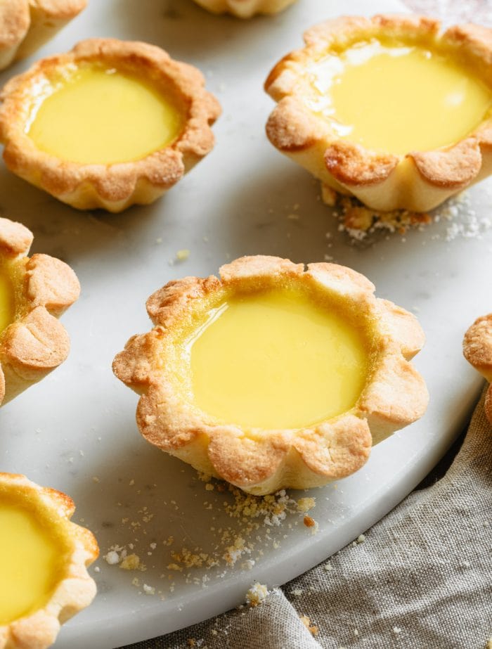 several egg tarts on a round marble board
