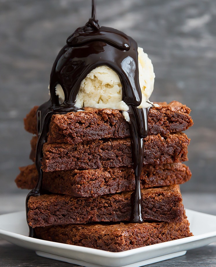photo of a stack of nutella brownies topped with ice cream and chocolate sauce