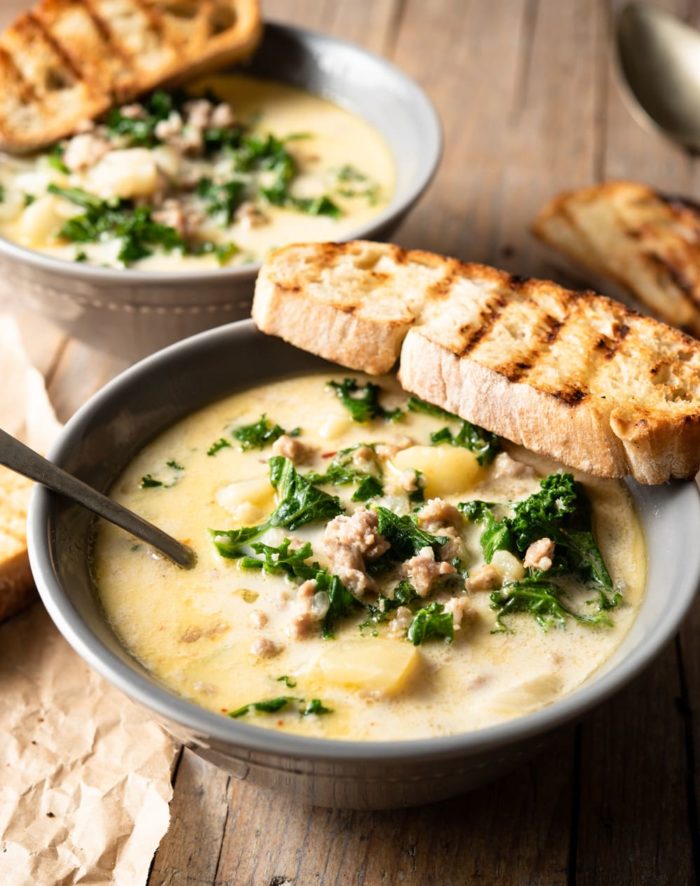 photo of a bowl of soup with a slice of grilled bread