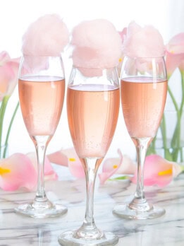 photo of glasses of champagne topped with cotton candy