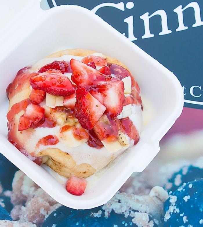 overhead photo of a cinnamon roll topped with strawberries