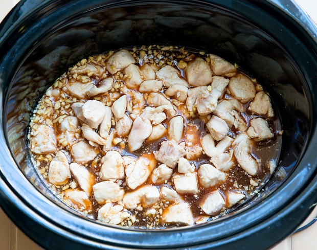 overhead photo of chicken and garlic honey sauce in a slow cooker