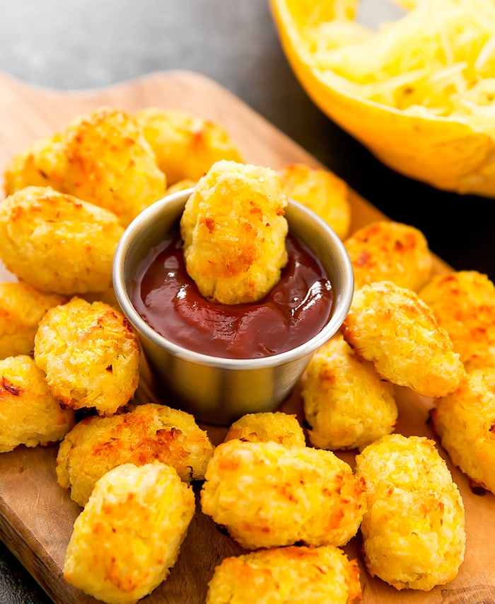 a close-up of a Spaghetti Squash Tater Tot in dipping sauce