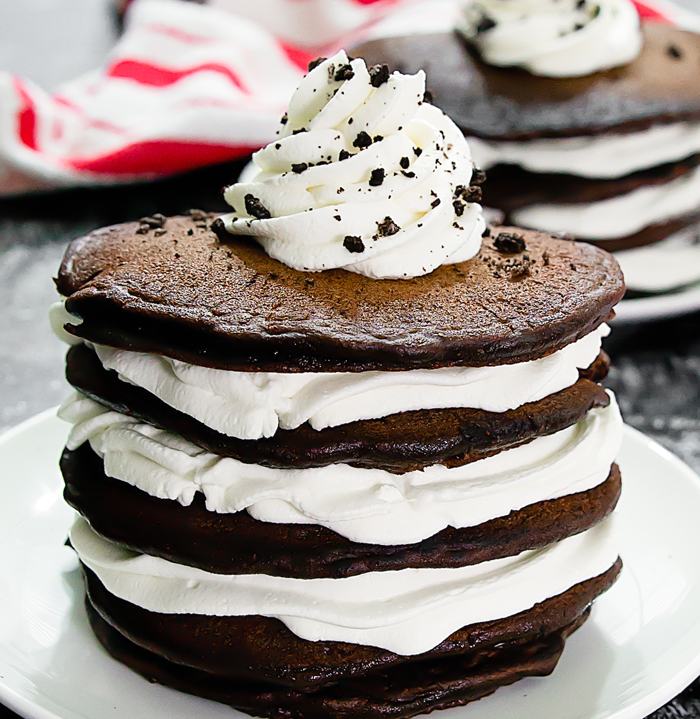 a close up shot of oreo pancakes garnishes with whipped cream