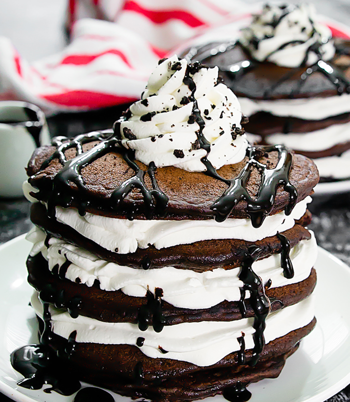 a big stack of oreo pancakes with chocolate syrup