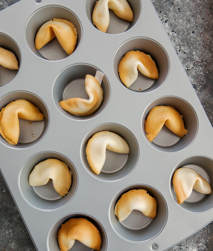 step by step photo of fortune cookies in a muffin tin for a second bake