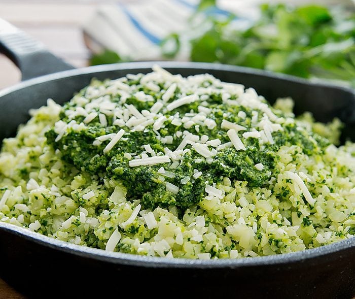 cauliflower rice topped with kale pesto and grated parmesan cheese