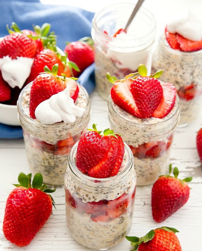 photo of jars of Strawberries and Cream Overnight Oats garnished with fresh strawberries