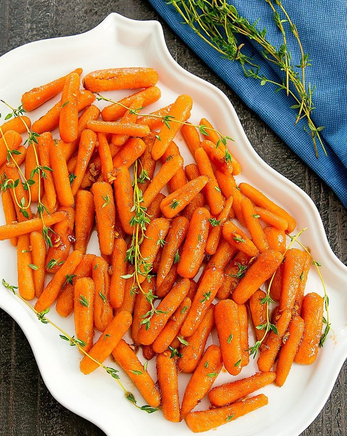 overhead photo of honey-garlic roasted carrots on a white serving platter