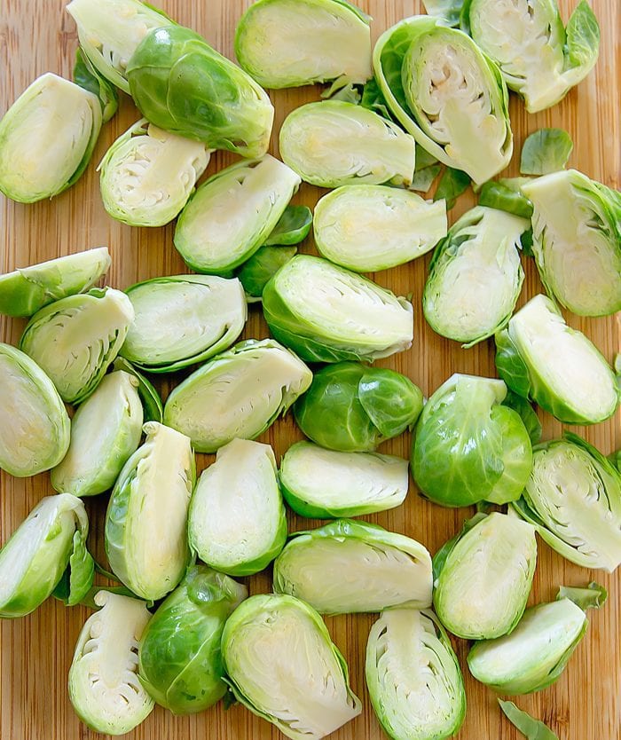 overhead prep shot of raw brussels sprouts sliced in half