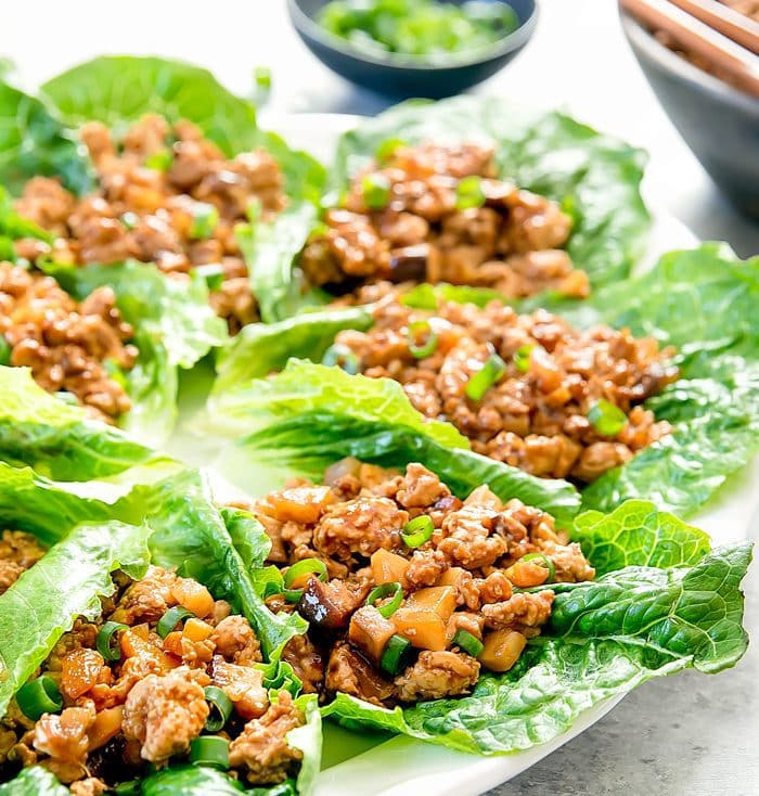 a close-up photo of PF Chang's chicken lettuce wraps on a white serving platter