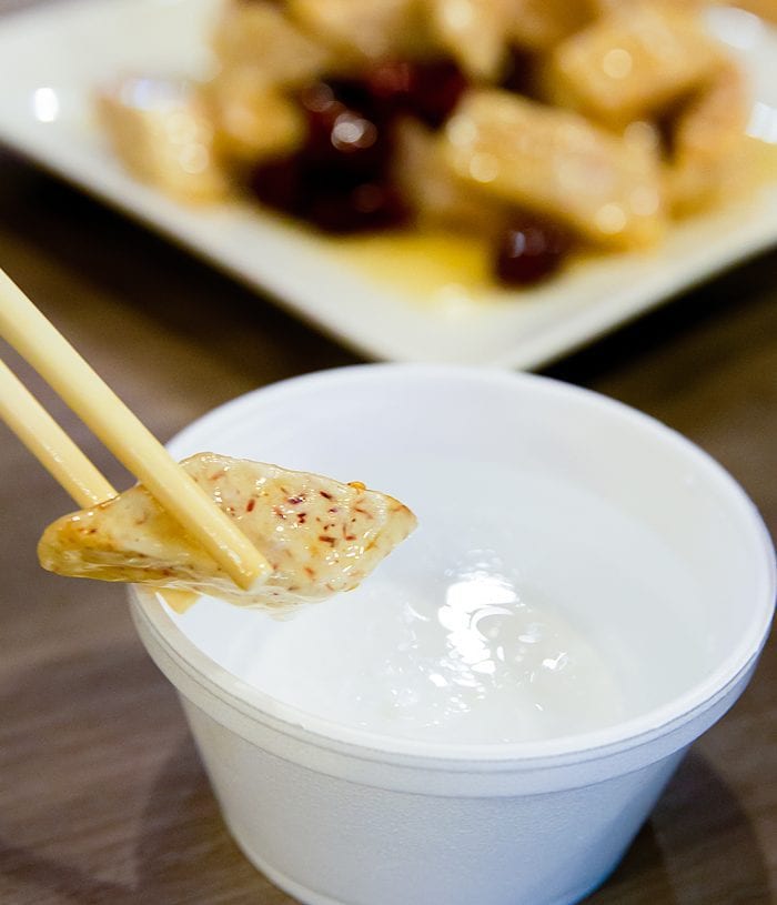 close-up photo of a piece of Fried Sweet Taro being dipped in sauce