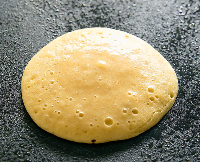 a pancake cooking on a skillet