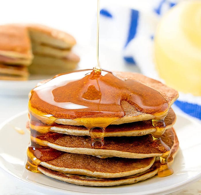 a stack of flourless banana pancakes with syrup being poured over the top