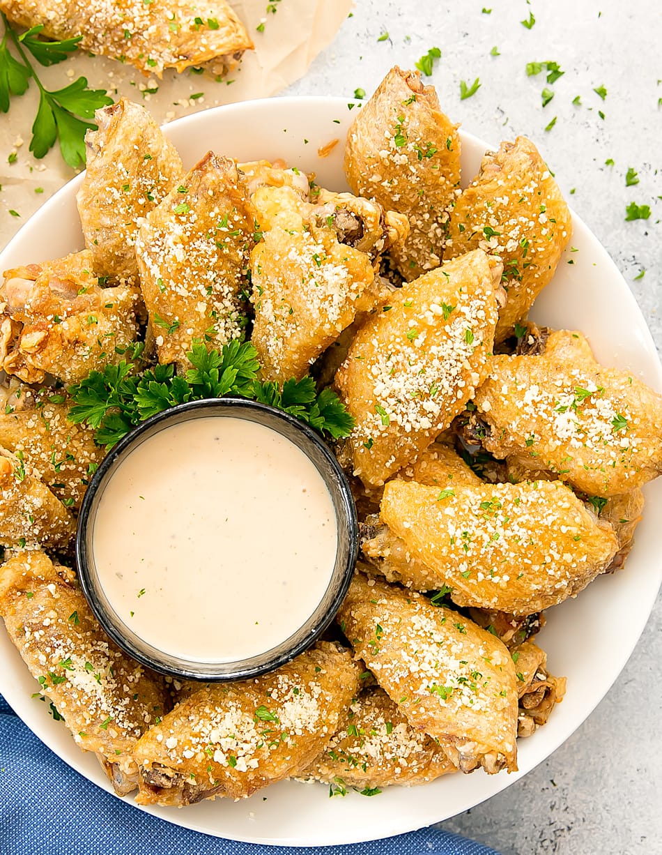 Baked Garlic Parmesan Wings on a platter with dipping sauce