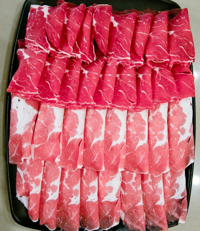 overhead photo of sliced raw beef and lamb