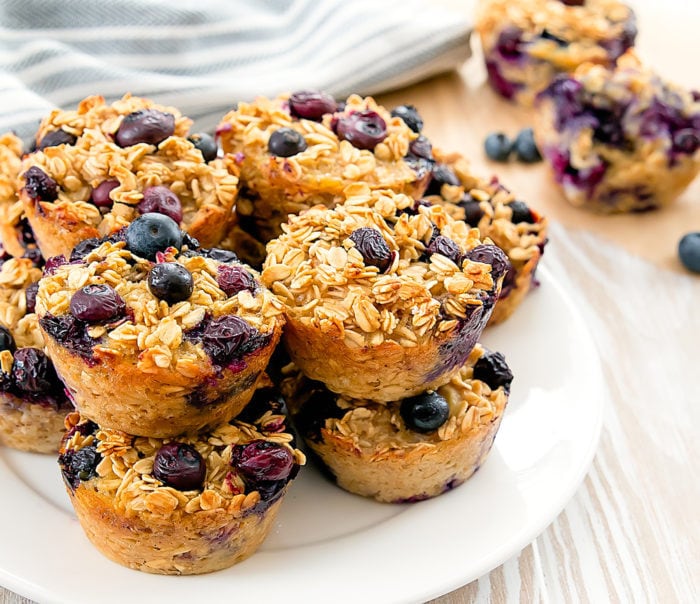a close-up photo of baked blueberry oatmeal cups on a white plate
