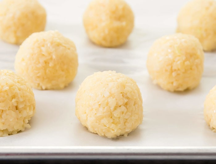 raw cauliflower rice balls on a baking sheet