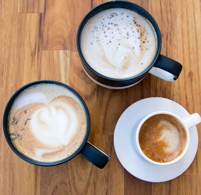 overhead photo of Lavender Vanilla Bean latte, Cardamom Orange Latte, and a Machiatto