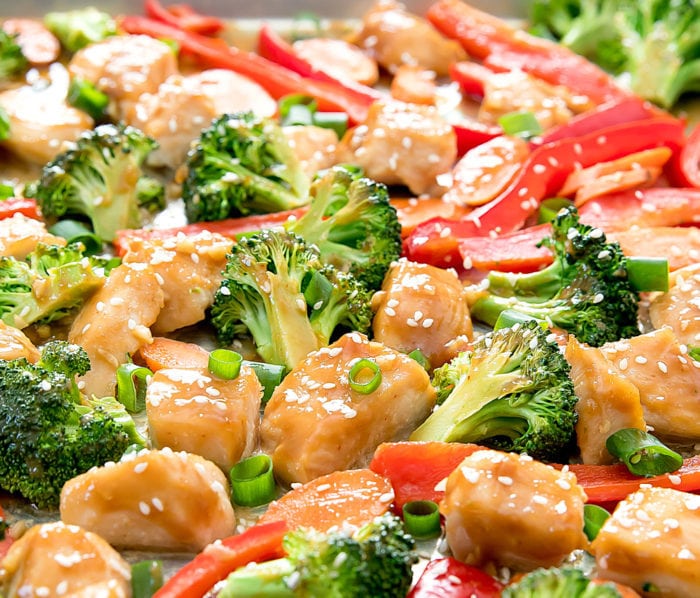 close-up of honey garlic chicken garnished with sliced green onions and sesame seeds