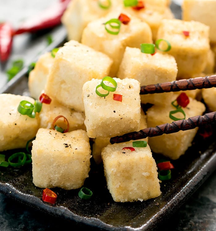 close-up photo of chopsticks holding a piece of Crispy Salt and Pepper Tofu