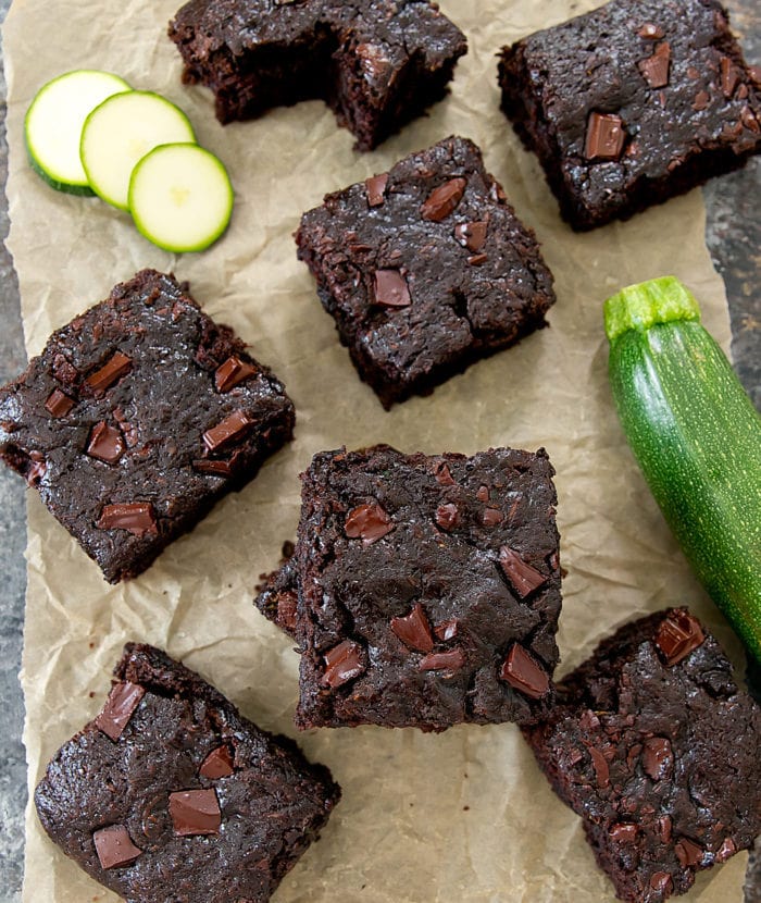 overhead photo of zucchini brownies scattered across parchment paper