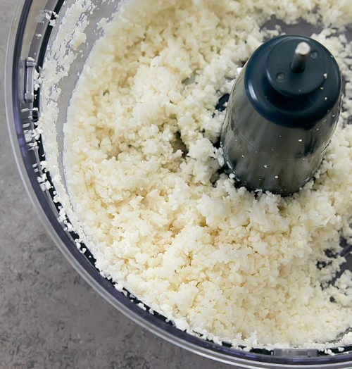 overhead photo of finely chopped cauliflower in a food processor