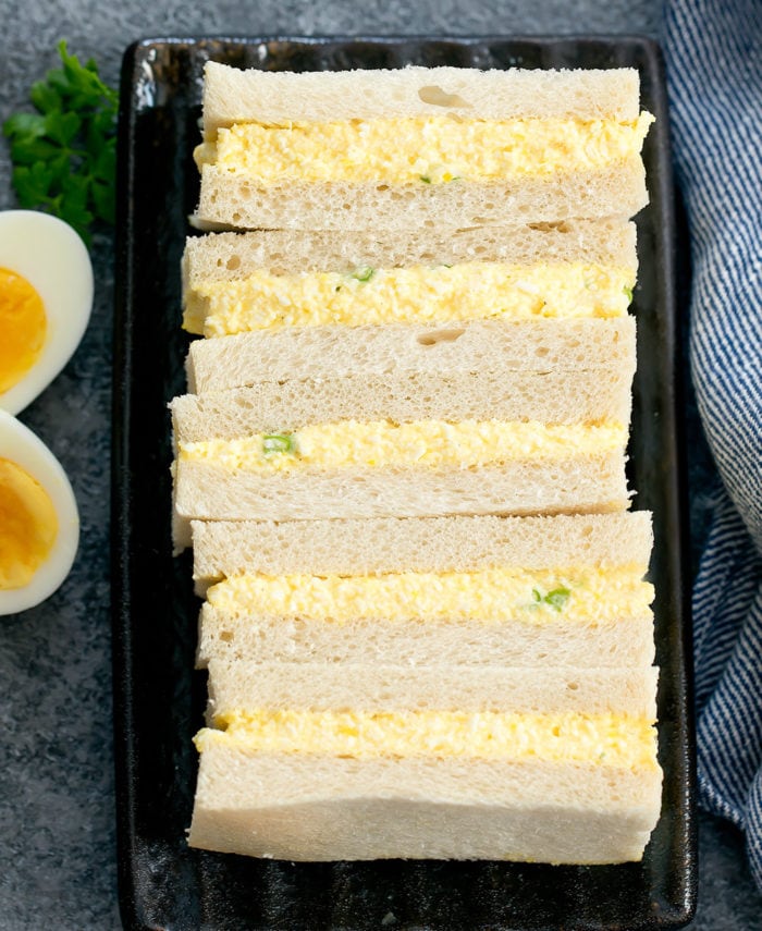 overhead photo of egg sandwiches lined up on a plate