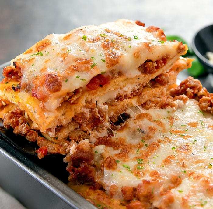 close-up photo of a slice of lasagna being lifted from a pan