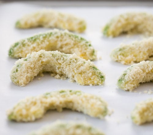 photo of breaded avocado fries on a sheet pan before they are baked