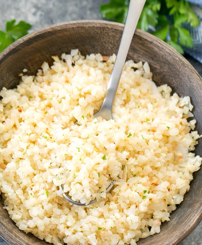 overhead photo of a bowl of Garlic Roasted Cauliflower Rice with a spoon