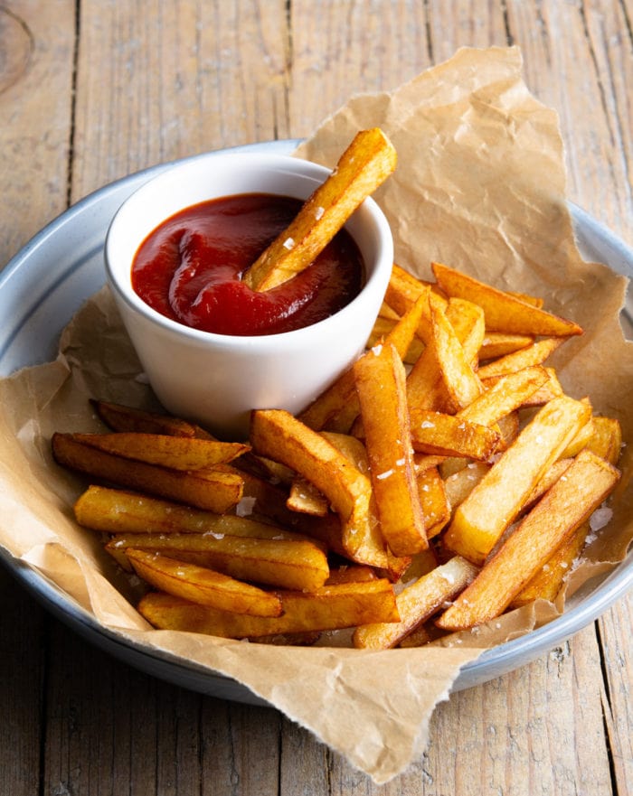 photo of a plate of french fries with a bowl of ketchup