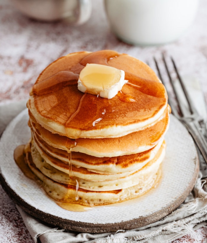 a stack of pancakes with butter and syrup