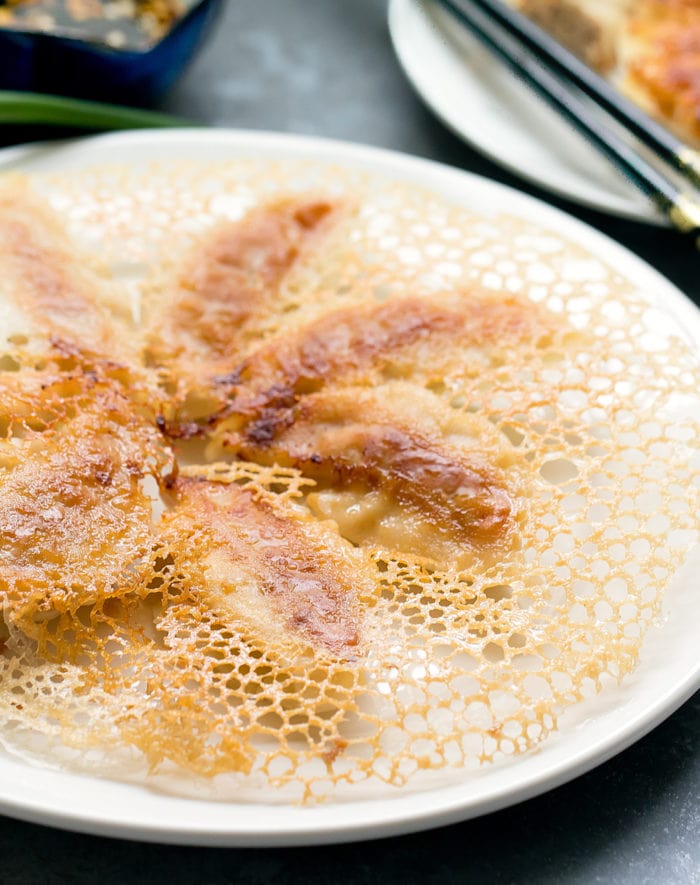 photo of potstickers on a plate topped with the crispy skirt