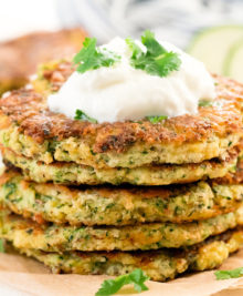 photo of a stack of zucchini fritters with sour cream