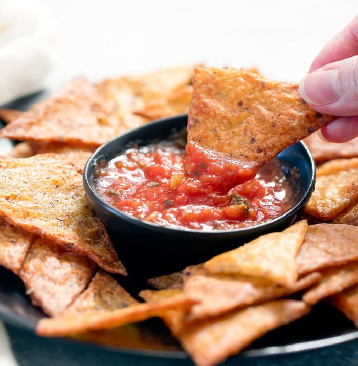 close-up photo of a chip being dipped in salsa
