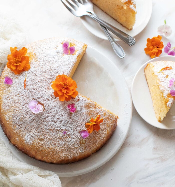 overhead photo of a sliced pound cake garnished with flowers.