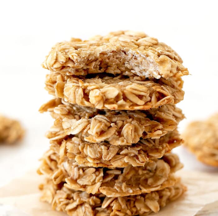 close-up shot of a stack of oatmeal cookies with a bite taken out of the top one.