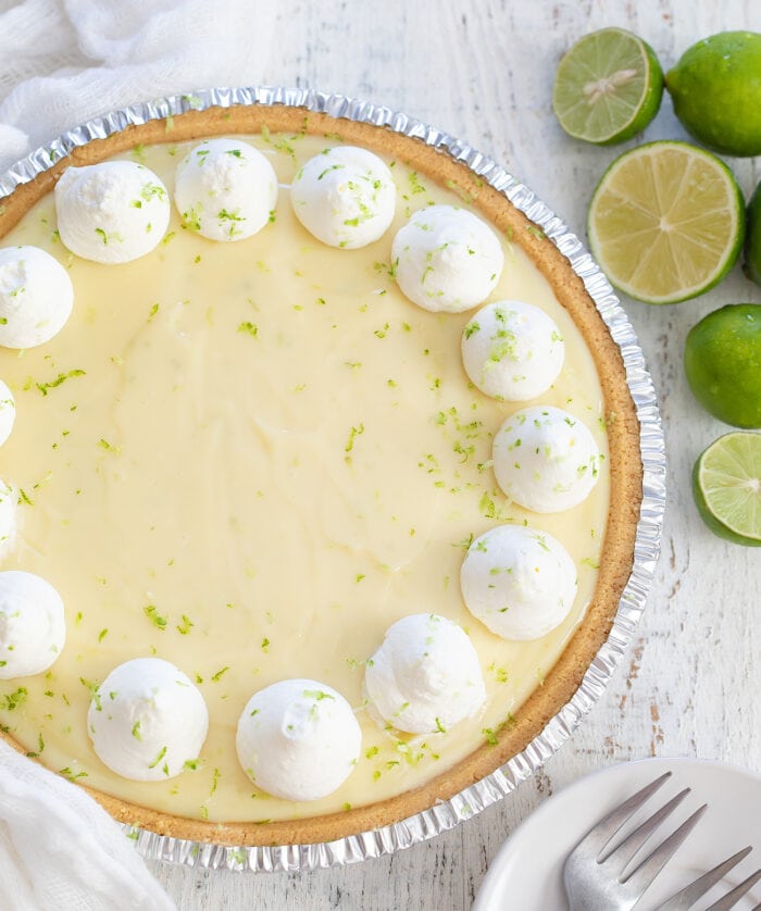 overhead shot of the whole key lime pie garnished with dollops of whipped cream.