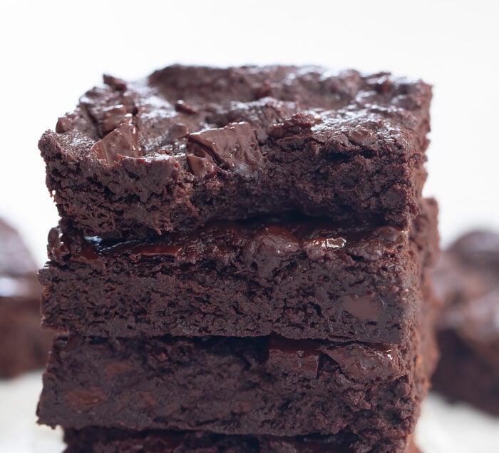 a stack of brownies with a bite taken out of the top one.