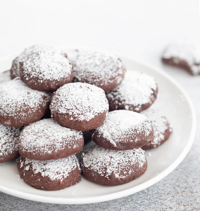 a plate of chocolate meltaway cookies dusted with powdered sugar.