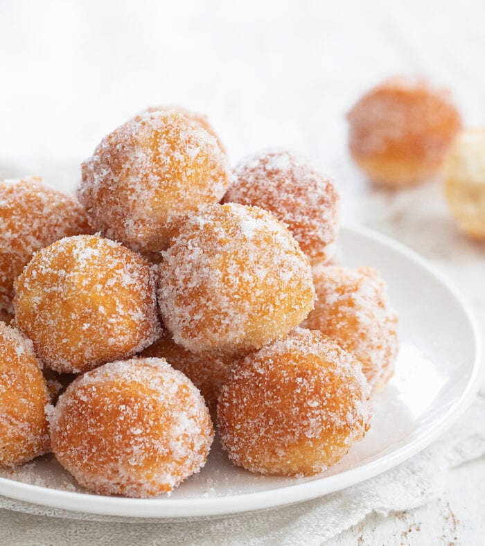 a plate of sugar coated donuts