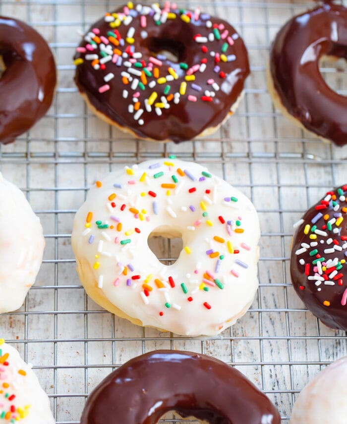sprinkle donuts on a baking rack.