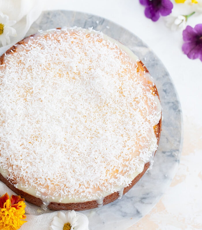 a whole coconut cake decorated with shredded coconut.