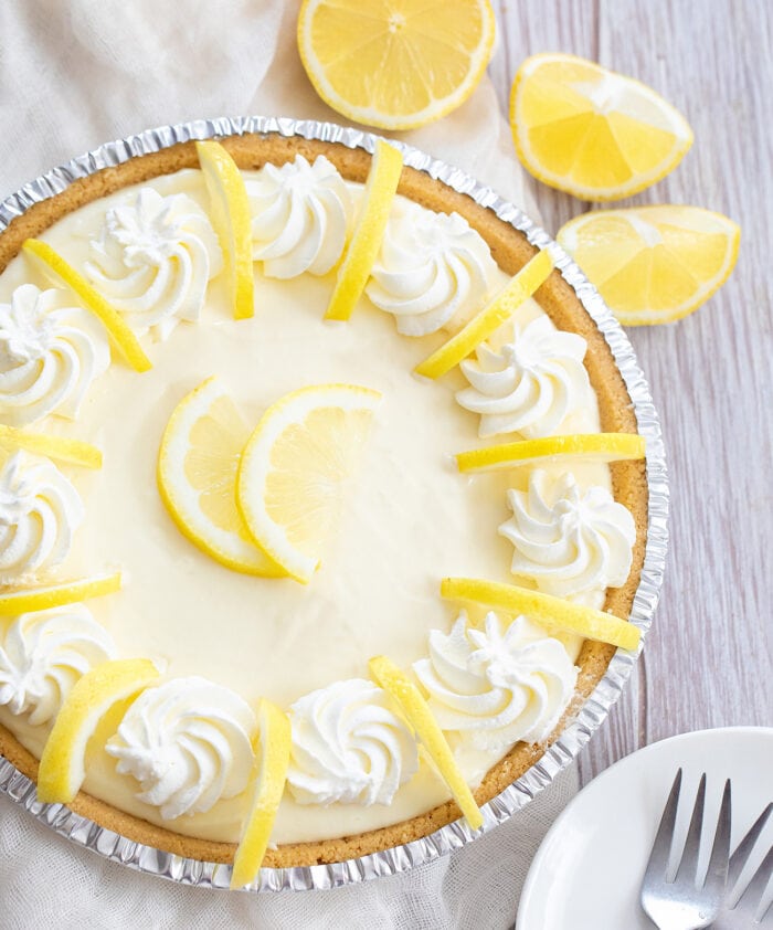 no bake lemon pie garnished with whipped cream and lemon slices.