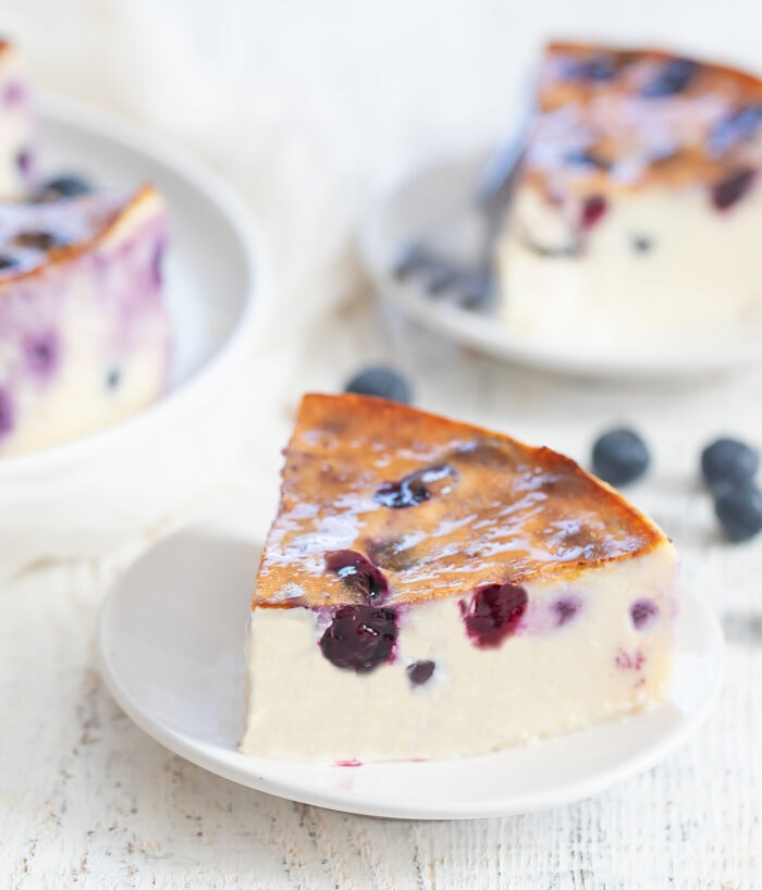 a slice of blueberry yogurt cake on a small white plate.