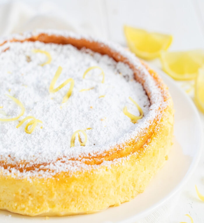 a whole lemon cheesecake dusted with powdered sugar.