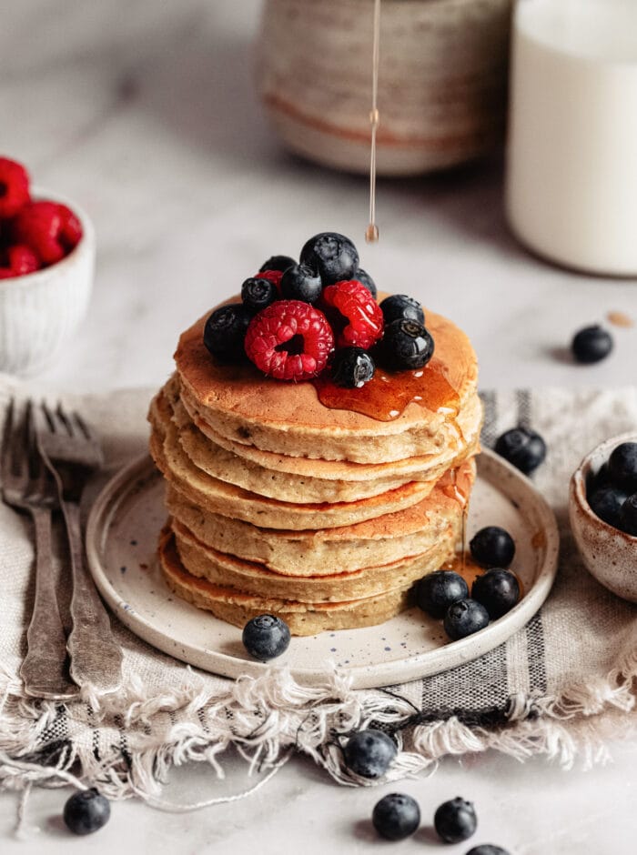syrup drizzled on a stack of oatmeal pancakes.