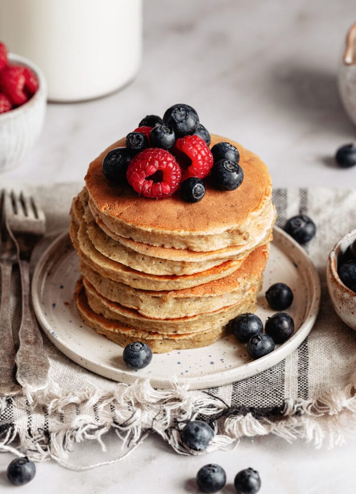 a stack of pancakes topped with fresh berries.